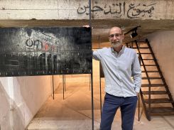Eugène Debbane devant une œuvre en acier représentant l’enseigne « L’Orient » du cinéma Rivoli à la place de Martyrs, Beyrouth, fragment d’un paysage urbain disparu que l’artiste grave dans la mémoire du métal. Photo Rayanne Tawil/L’Orient-Le Jour