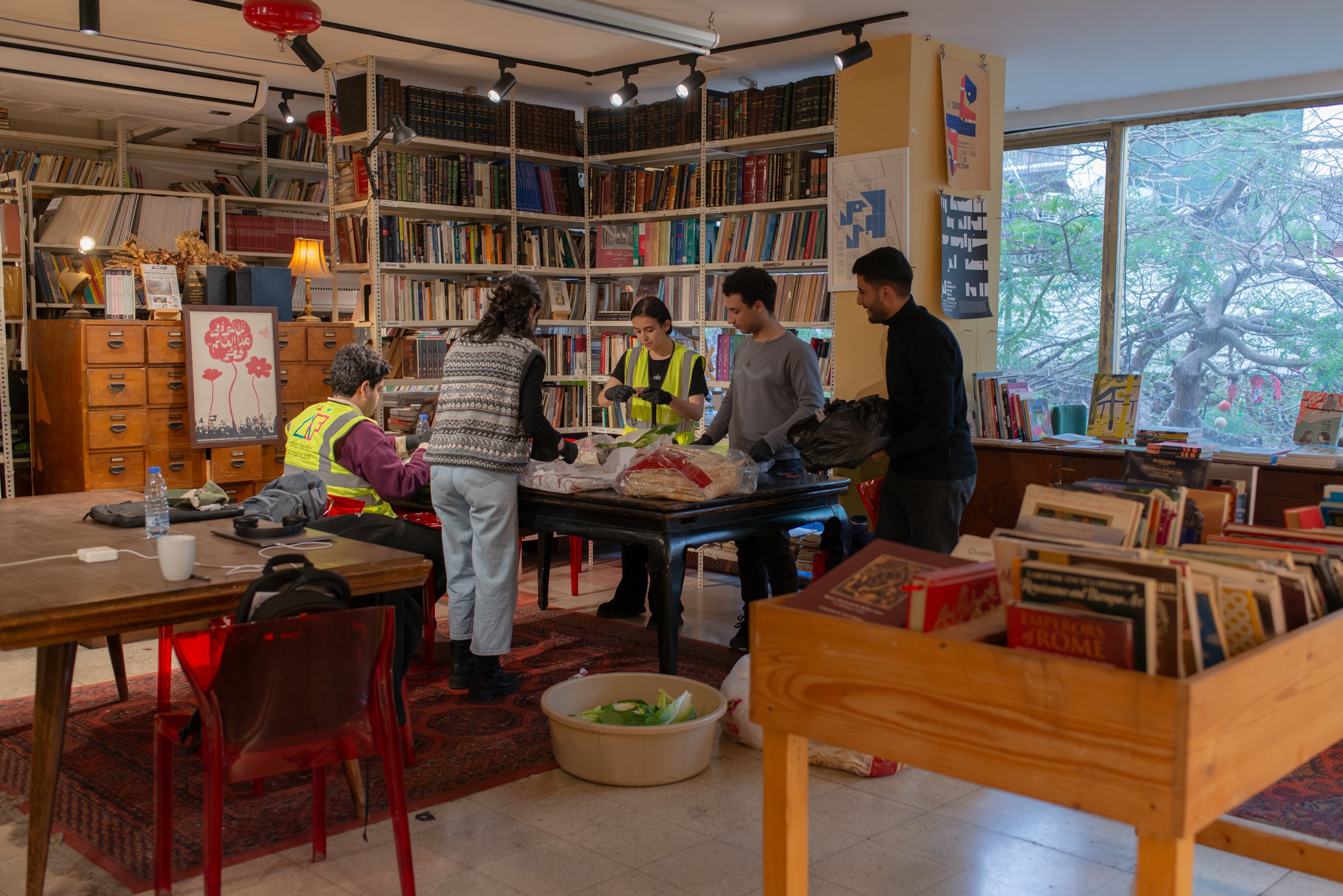 Since the beginning of the latest escalation, the Barzakh cafe-bookshop in Hamra has been using its space to prepare meals for displaced families. Here, a group is seen preparing sandwiches to be distributed for dinner, on March 28, 2026. (Credit: Ségolène Ragu/L’Orient Today)