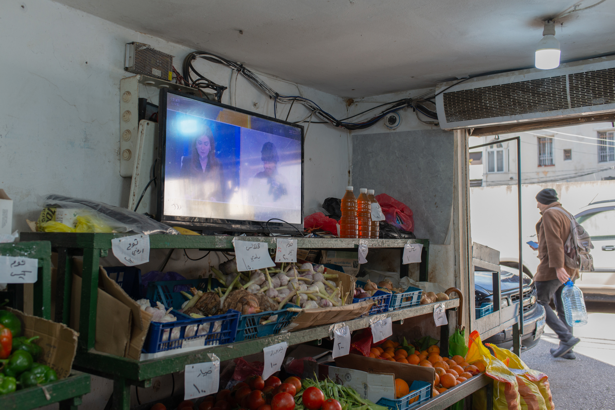 A shopkeeper keeps the television on in his store to follow the news, in Geitawi, on March 28, 2026. 
(Credit: Ségolène Ragu/L’Orient Today)
