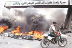 Un motard sur l'autoroute de l'aéroport de Beyrouth, bloquée par des pneus brûlés par des partisans du Hezbollah, le 7 mai 2008. Photo d'archives AFP/Ramzi Haidar