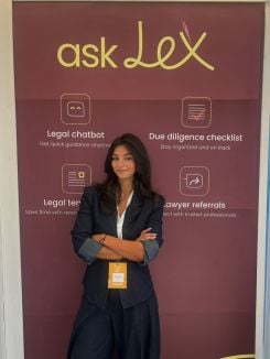May El-Hachem posant devant une affiche présentant askLex lors du Techne Summit au Caire en septembre 2025, Photo fournie par May El-Hachem