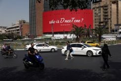 People near a billboard with a slogan referring to U.S. President Donald Trump and a hashtag referring to late U.S. Senator Lindsay Graham, in Tehran, Iran, July 27, 2026. (Credit: Majid Asgaripour/WANA/Reuters)
