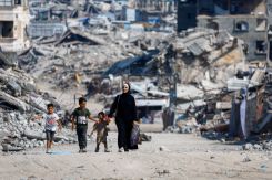 Une famille de déplacés palestiniens marche dans les ruines d'un quartier résidentiel de la ville de Gaza, le 15 août 2026. Photo Mahmoud Issa/Reuters