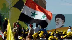 Des partisans du Hezbollah agitent un drapeau syrien sous un immense portrait de l'ancien guide suprême de la révolution iranienne, l’ayatollah Ali Khamenei, lors d’un rassemblement dans la ville de Bint Jbeil, au Liban-Sud, le 25 mai 2012. Photo d'archives Mahmoud Zayyat/AFP